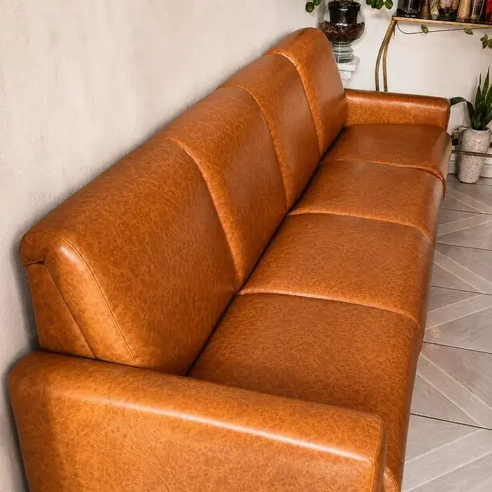 Sofá em couro caramelo, com costura reforçada