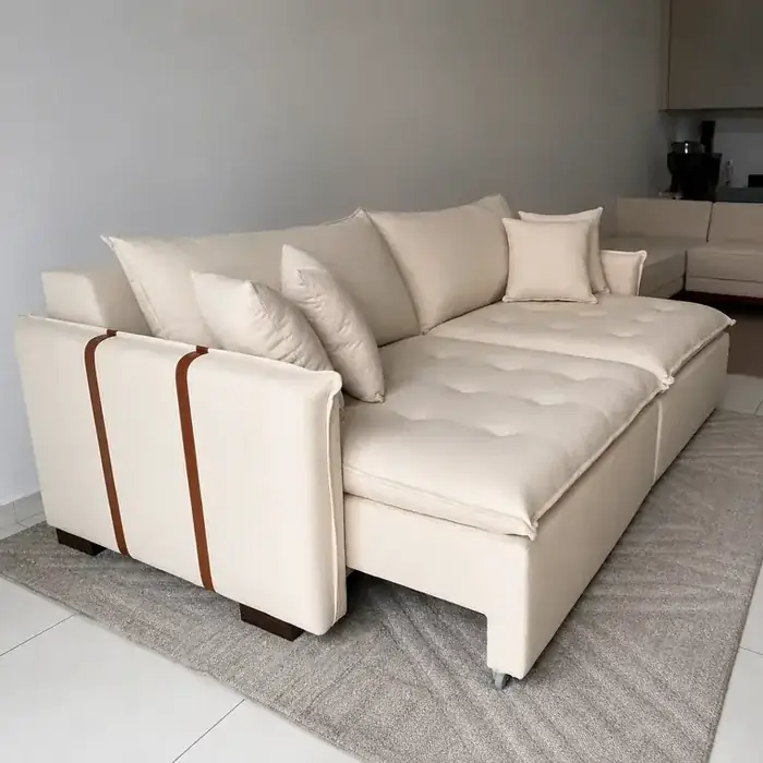 Sofá retrátil em tecido creme, com detalhes em couro